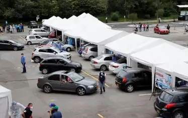 Колумбийци са се наредили на опашки в колите си, за да получат доза от ваксина срещу COVID-19 в Богота. До момента в страната са имунизирани над 3 млн. души.