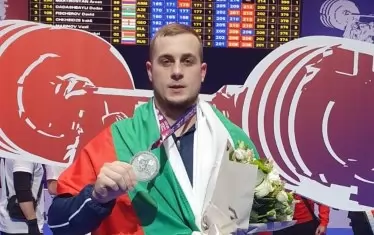  Дейвид Фишеров позира със сребърния си медал от изтласкването.