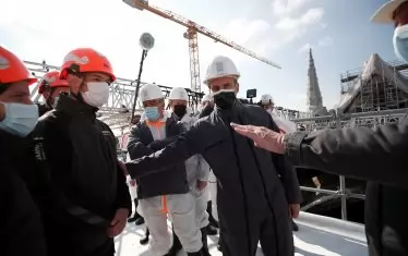 Еманюел Макрон (в средата), със защитна каска и маска, дойде да проследи възстановяването на катедралата. 