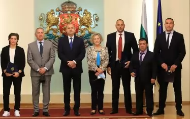 Президентът Румен Радев и назначеният от него служебен министър на младежта и спорта Андрей Кузманов позират с наградените с Почетния знак на държавния глава Тайбе Юсеин (вляво), Кубрат Пулев, Иван Иванов, Петър Стойчев и Нешка Робева (от дясно на ляво) след церемонията в Гербовата зала.