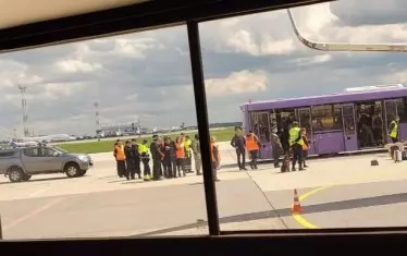  Автобус откарва пътниците в терминала на летището в Минск, за да чакат разрешение да продължат полета си.