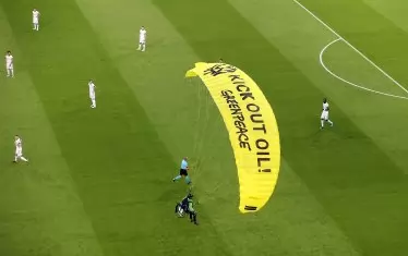 Екоактивистът от "Грийнпийс" каца на терена на "Алианц Арена" пред слисаните погледи на германските национали, подготвящи се за началото на мача срещу Франция.