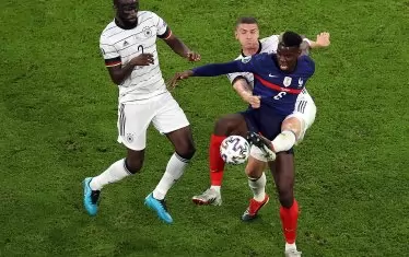 Плеймейкърът на Франция Пол Погба е приклещен в борбата за топката от германските защитници Антонио Рюдигер (вляво) и Робин Гозенс (отзад).