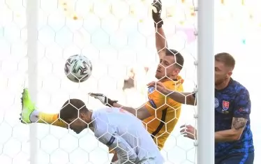 Вратарят на Словакия Мартин Дубравка (в средата) е забил с лявата ръка топката във вратата си, притиснат от испанския централен нападател Алваро Мората (вляво) и пред безпомощния поглед на съотборника си Милан Шкриняр (вдясно).