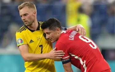 Шведският халф Себастиан Ларсон (вляво) успокоява полския голмайстор Роберт Левандовски след последния съдийски сигнал на мача в Санкт Петербург, оказал се последен за "дружина полска" на Евро 2020.