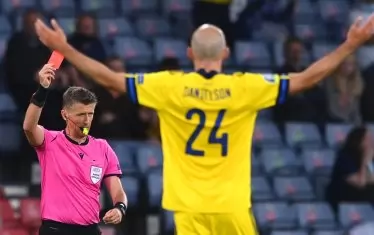 Шведският бранител Маркус Даниелсон е вдигнал безпомощно ръце, виждайки как италианският съдия Даниеле Орсато му показва червен картон в средата на първото продължение срещу Украйна.