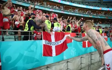 Капитанът на Дания Симон Кяер хвърля фланелката си на щастлив запалянко от скандинавската агитка, подкрепяла тима в Баку.