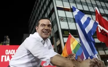 Готин, усмихнат, с бяла риза и навити ръкави - Ципрас ръкостиска фенове, капитализирайки определен тип политическа визия.