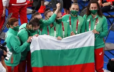 Петте момичета и техните треньори - Весела Димитрова (вляво) и Михаела Маевска (вдясно), държат гордо българския трибагреник след паметната олимпийска титла.