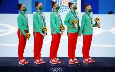 Олимпийските шампионки слушат "Мила родино" от най-високото стъпало на почетната стълбичка в гимнастическия център "Ариаке" в японската столица.