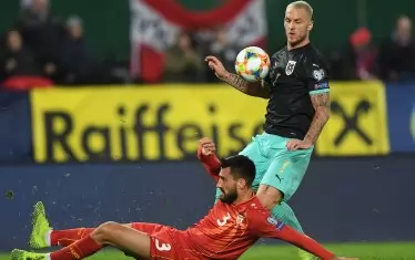 Гьоко Зайков (на тревата) срещу австрийския нападател Марко Арнаутович в мач от група G на европейското първенство.