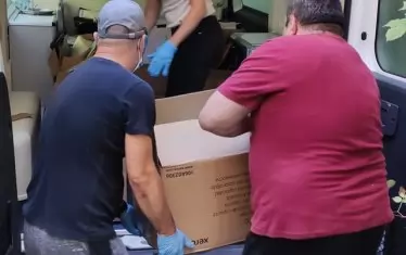 Екипът на РЗИ качва досиетата на микробус.