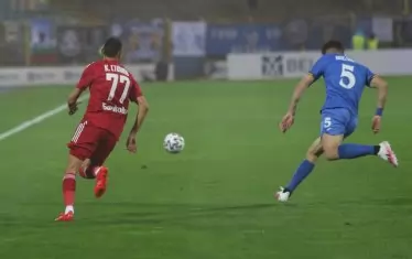 Кипърският бранител на "сините" Христос Сиелис и халфът на "червените" Крум Стоянов са се втурнали след топката в средата на терена.