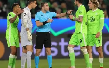 Българският рефер Георги Кабаков показва категорично на футболистите на "Волфсбург", че е отсъдил дузпа за "Севиля", от която испанският тим достигна до 1:1 в гостуването си в Германия.