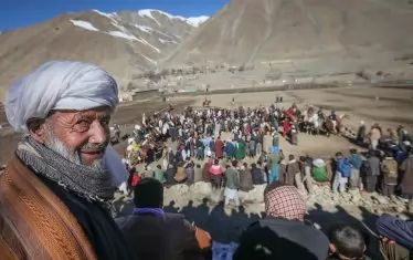  Зрител наблюдава традиционната игра бузкаши, при която играчите яздят коне и се опитват да вкарат гол с труп на коза или теле. Играта няма конкретни правила и може да продължи, докато играчите и конете имат сили.