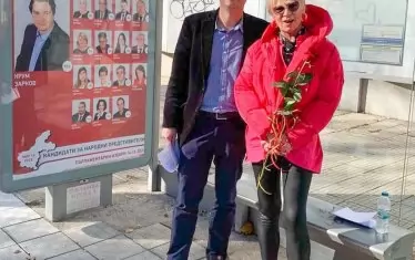 Колкото да се старае, Крум Зарков не може да стигне тематичния стайлинг на Нона Йотова. Но какво правят на автобусна спирка?