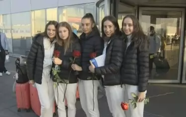 Момичетата от ансамбъла получиха по една роза при излизането си от летище "София".