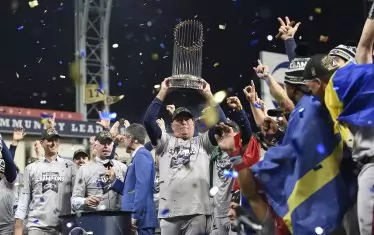 Мениджърът на "смелчаците" Брайън Сниткър е вдигнал над главата си Трофея на комисионера - шампионската купа на МЛБ.