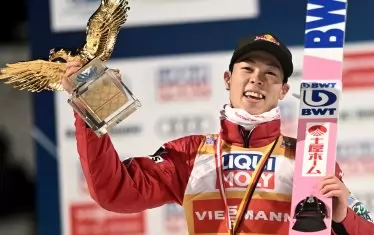 Победителят в "Четирите шанци" за сезон 2021/2022 Рьою Кобаяши позира със "Златния орел" на почетната стълбичка в Бишофсхофен.