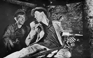 Пропагандна снимка на Стаханов в мината с негов другар, която прославя радостта от непосилния труд.