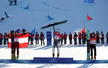 Непобедимата Естер Ледецка е вдигнала своя сноуборд, докато ликува на най-високото стъпало на олимпийската стълбичка в компанията на подгласничките си - Даниела Улбинг (вляво) и Глория Котник (вдясно).