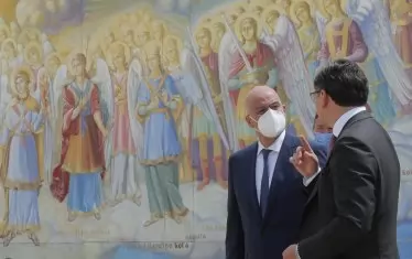 Украинският външен министър Дмитро Кулеба (вдясно) и гръцкият му колега Никос Дендиас (вляво) пред стенописите на катедралата ''Св. Архангел Михаил'' в Киев.