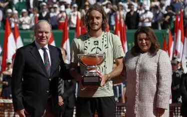 Новият стар шампион Стефанос Циципас позира с трофея от "Мастърс" в Монте Карло в компанията на принца на Монако Албер II и президента на местната тенис федерация Мелани дьо Маси след церемонията по награждаване на централния корт "Рение III".