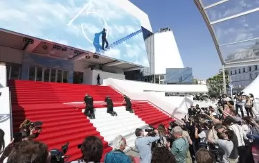 Работници покриват с червен килим стълбите на Фестивалния дворец пред фотографските обективи по-рано днес.