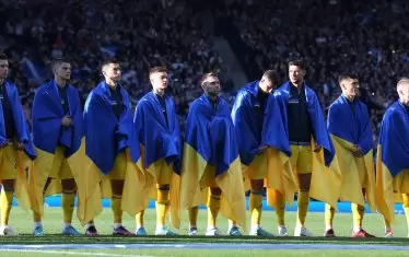 Преди мача всички украински национали излязоха наметнати с националния флаг на родината си.