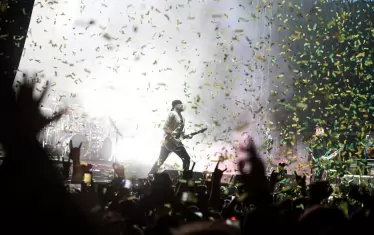 Китаристът Анди Джеймс под заря от конфети.