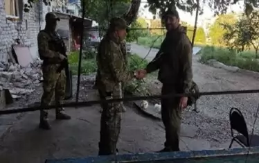 Счита се, че човекът с камуфлажните дрехи (вляво), който се ръкува с военния кореспондент е Пригожин