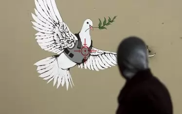 Друга от творбите на Банкси, нарисувани на стената на Западния бряг през 2007 г., изобразява гълъб на мира с бронежилетка.