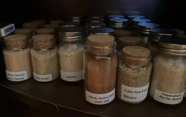 Част от колекцията му с пясък от различни плажове по света.