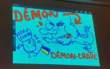 Плантю демонстрира по време на дебата как рисува на таблета си, като представи на голям екран своето виждане за днешните демони на Европа: змей с образа на Путин и игра на думи - вместо "Демокрация", написа "Демон-крация".