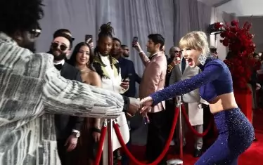 Тейлър Суифт (вдясно) поздравява колегата си Questlove на червения килим.