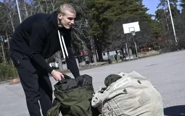 Баскетболистът прибира подготвените му военни принадлежности.