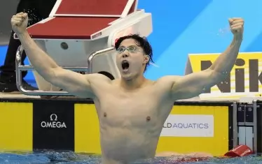 Цин Ханян излъчва могъщество, гледайки към светлинното табло във Фукуока, увековечило световния му рекорд на 200 м бруст.