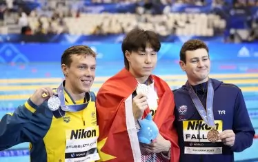 Китайският шампион и подгласниците му Зак Стъблети-Кук (вляво) и Мат Фалън (вдясно) след награждаването.