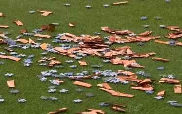 Частите от мозайката и конфетите, разпилени по игралната настилка.