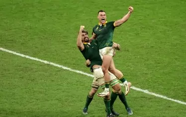 Един от стълбовете в южноафриканската предна линия - Ебен Етцебет (вляво) е вдигнал във въздуха Джеси Крийл, докато двамата празнуват спечелването на световната титла.