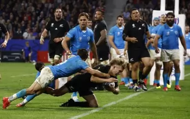 Новозеландският фулбек Деймиън Макензи (с топката) не може да бъде удържан при отбелязването на поредното есе за отбора си срещу Уругвай по време на двубоя в Лион.