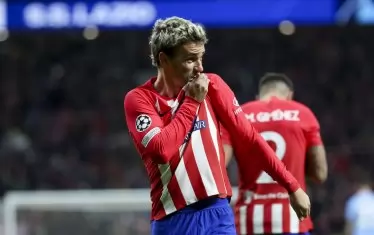 Френският национал Антоан Гризман целува емблемата на "Атлетико" (Мадрид) върху екипа си, след като е открил резултата срещу "Лацио" в директния сблъсък за първото място в група Е в Мадрид.