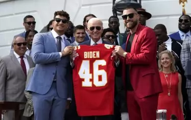 Травис Келси (в червено) и негов съотборник поднасят на Джо Байдън фланелка с името му, след като "Канзас Сити Чийфс" спечелиха предишния "Супербоул".