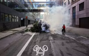 Полиция гаси купчина горящи борови дървета по време на протест на фермери до Европейския парламент по време на срещата на върха на ЕС в Брюксел на 1 февруари 2024 г.