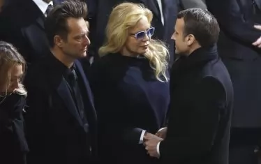 Певицата заедно със сина си Давид Холидей (вляво) и френския президент Еманюел Макрон на погребението на Джони Холидей през 2017 г.