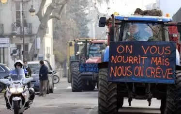  Протестиращи селяни във френско градче. На плаката пише: "Ние ви храним, но ще пукнем от глад".