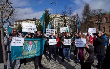 Протестиращите от Сливенската епархия носят саморъчно направени плакати против новата наредба за избор на митрополити...
