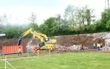 На мястото на досегашните трибуни са влезли багери, които събират отпадъците и ги подготвят за извозване.