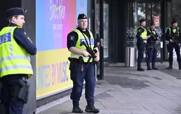  Тежко въоръжени полицаи патрулират пред залата. 