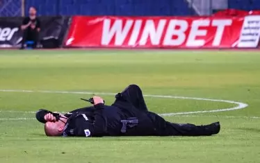 Ранен полицай лежи на терена на Националния стадион "Васил Левски" в центъра на София, малко преди да бъде откаран с линейка.